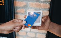 a person handing a credit card to another person